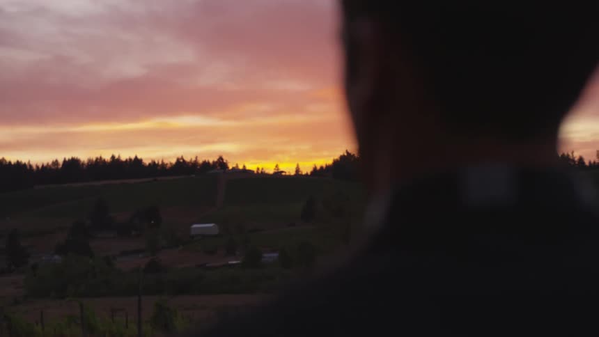 A man looks out over the hills at dawn