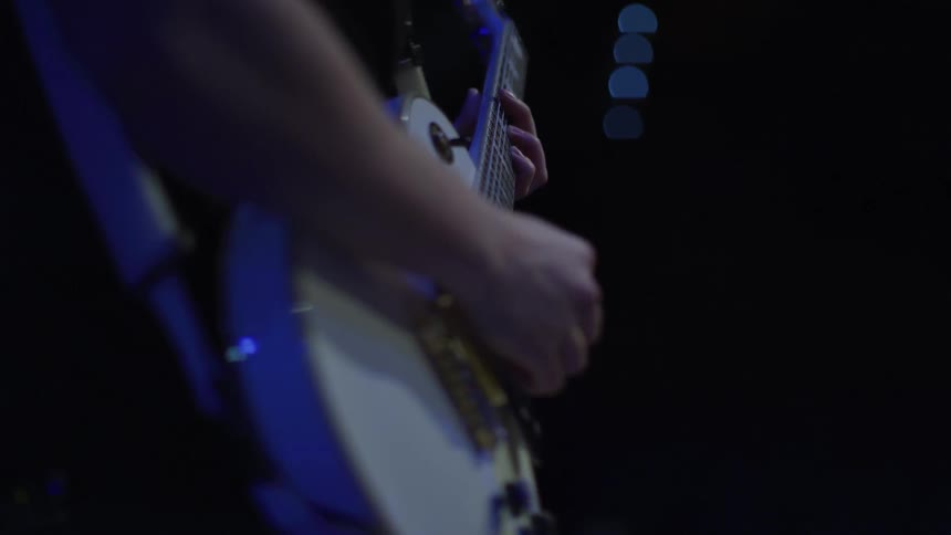 A guitarist plays on a stage
