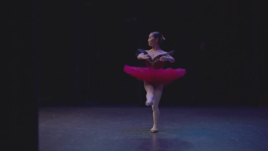 A ballerina spins with her leg up