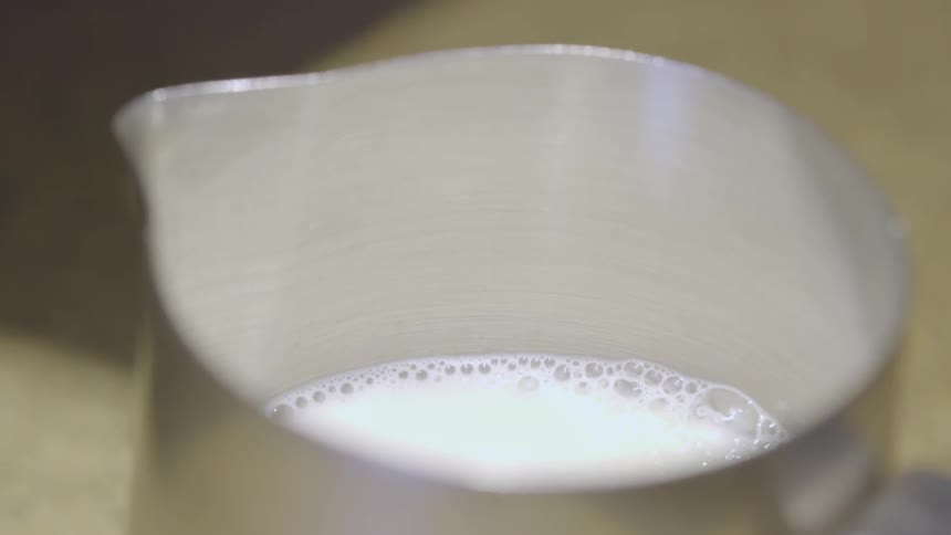 The pitcher on the table is half full with milk