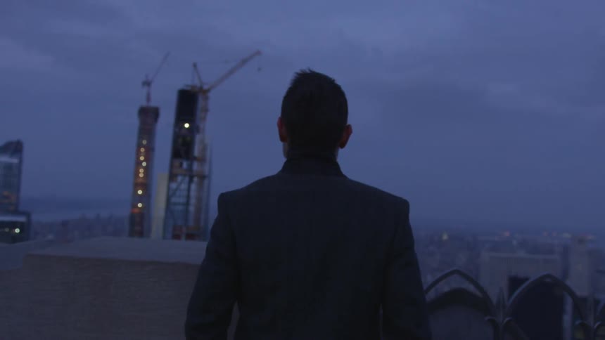 A man stands in a city at night