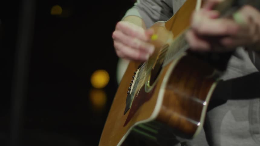 The person slowly strums the guitar