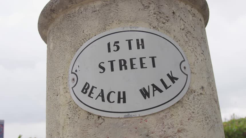 The circular sign sits on the stone pillar