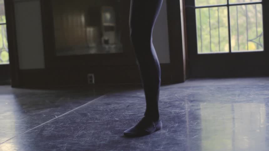 Person practices dancing and twirls around in an empty room