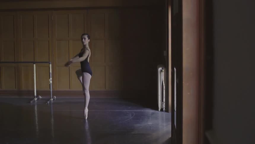 A ballerina pirouettes in a dance studio