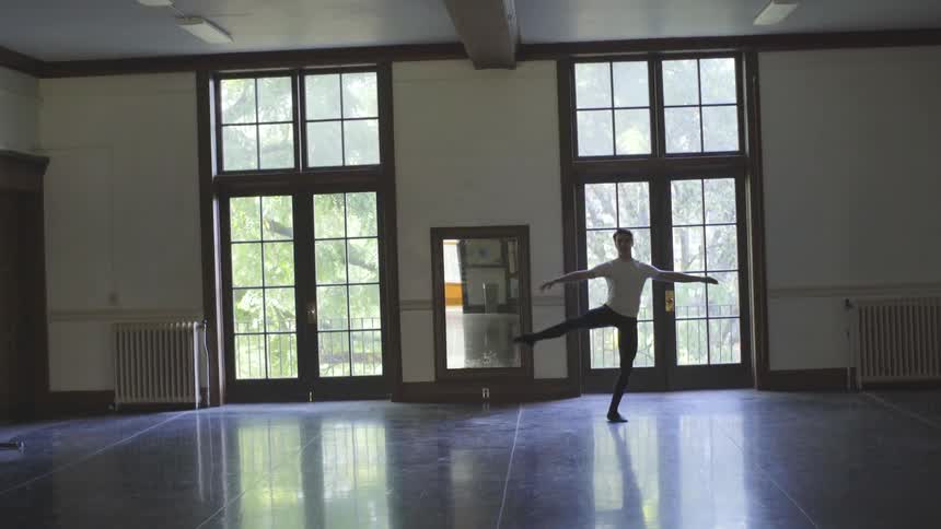 A male dancer pirouettes in a dance studio