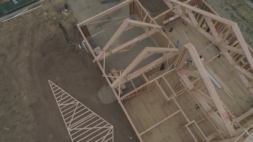 Several construction workers build a house
