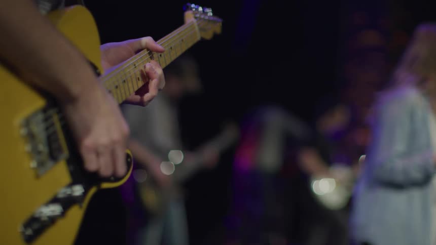 A man plays guitar as a woman sings