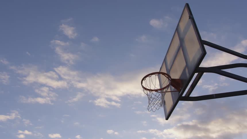 Clouds float above an outdoor basketball hoop