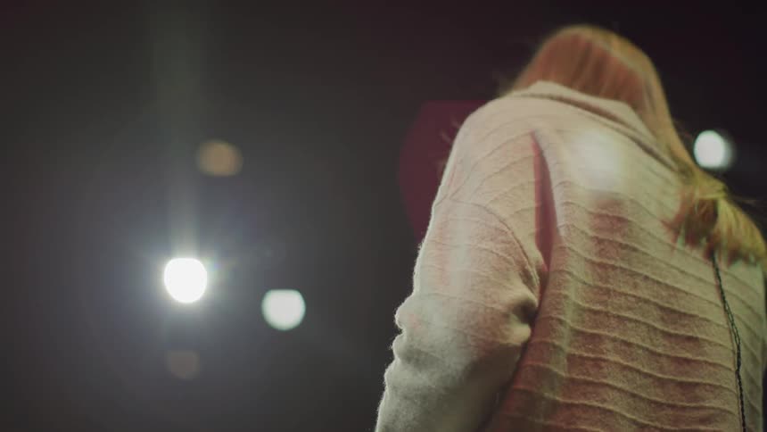 A woman on a stage sings into a microphone