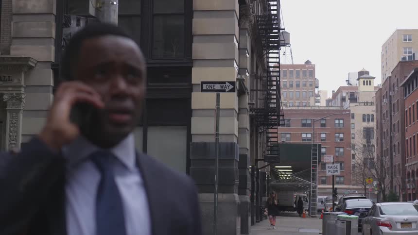 A man talks on his phone in front of the building