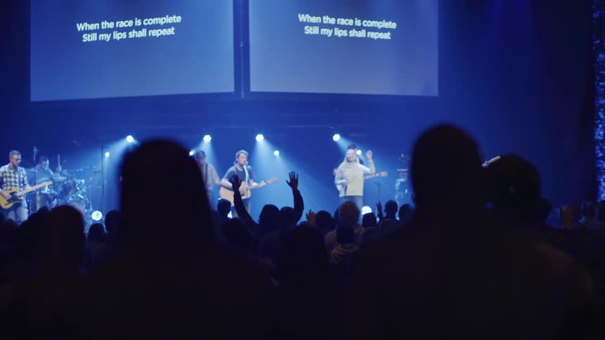 Lyrics of a song are projected over the stage and the audience sings along