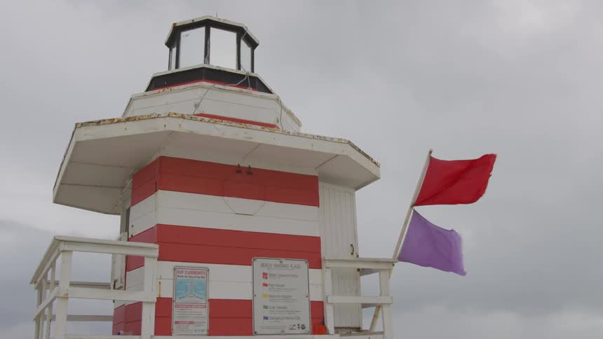 The flags blow in the air of the lifeguard stand
