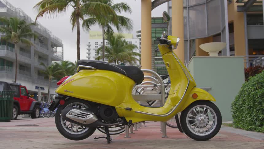 A yellow scooter is parked outside the building