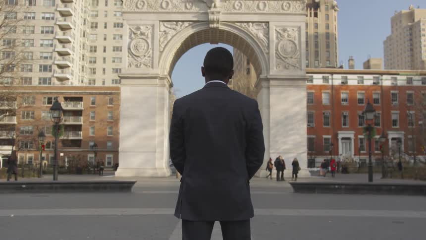 A businessman stands on a city sidewalk