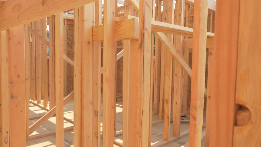 The sun is shining on the beams of the house being developed