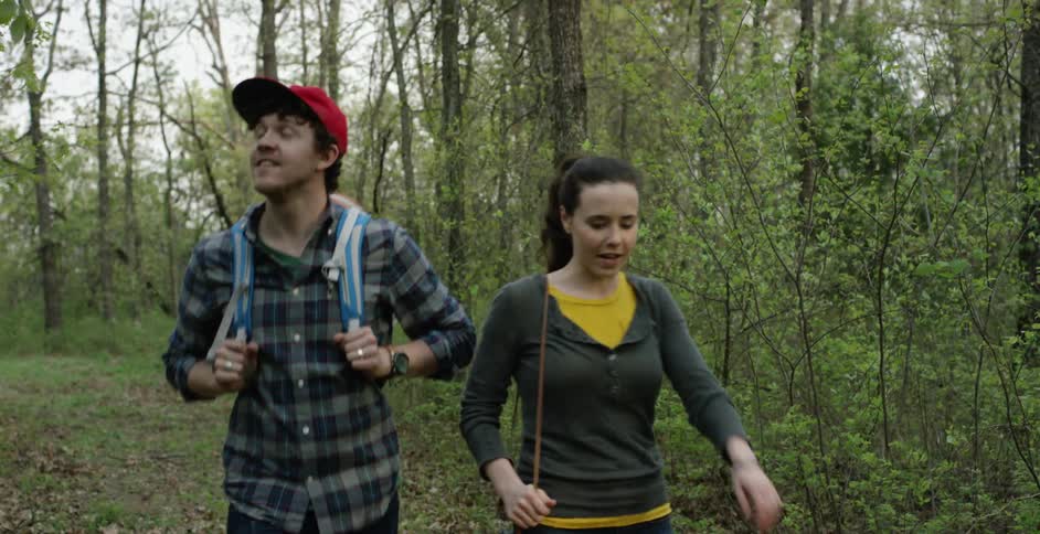 A man and woman hiking through the woods