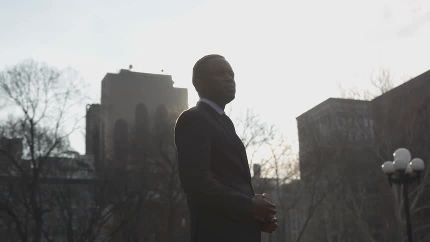 Man stands outside in the city on a sunny day