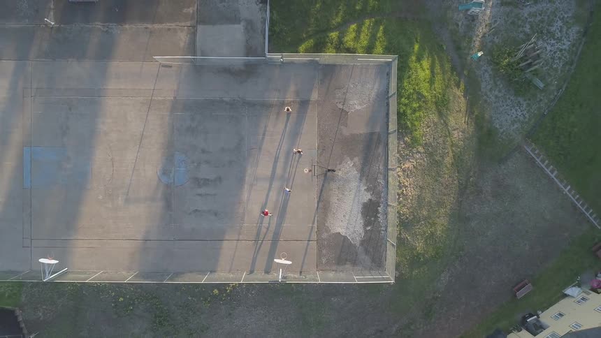 People play basketball on an outdoor court