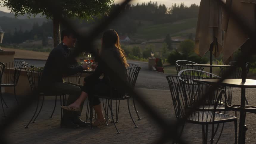 The man and woman have wine in the yard