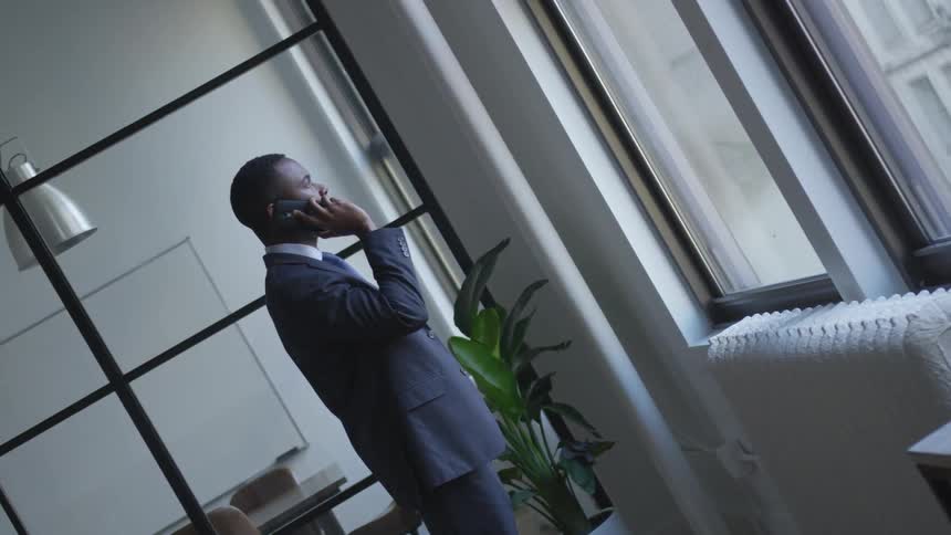 A businessman talks on a phone in an office
