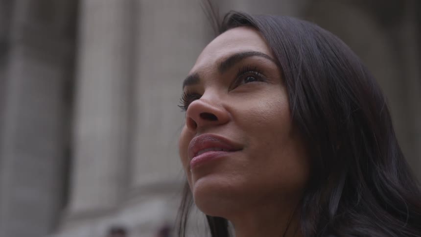 A woman is smiling near the stone building