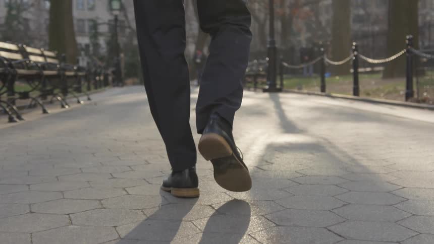 A person walks slowly in the park