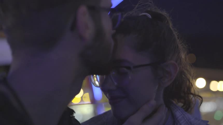 A man kisses a woman on the forehead