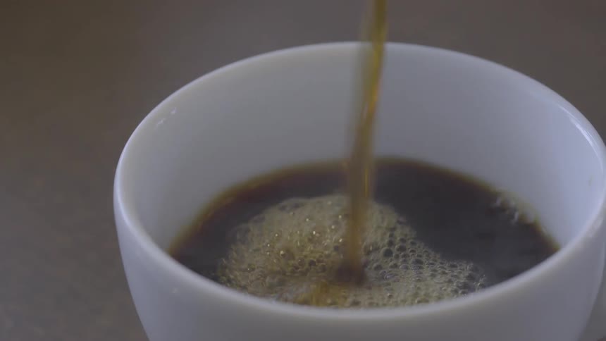 Coffee is being poured into a coffee cup