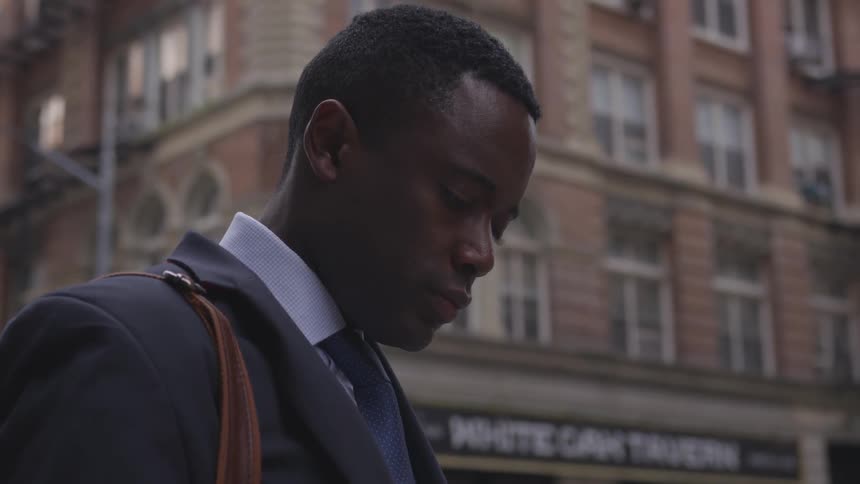 A man looks down as he travels in the city
