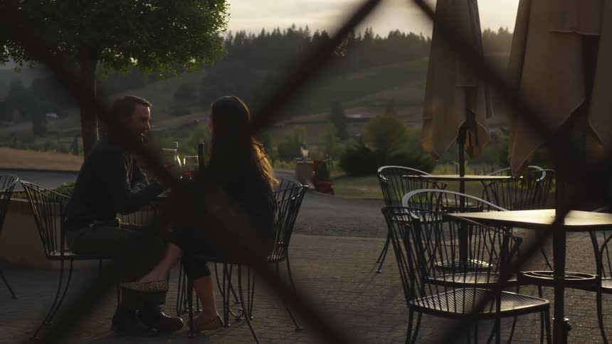 Man and woman eat dinner outside on a patio