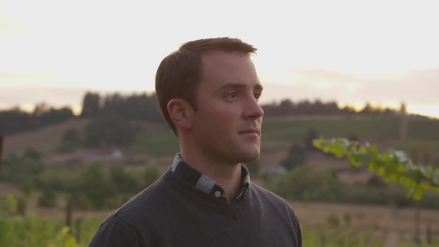 The man is smiling in the vineyard