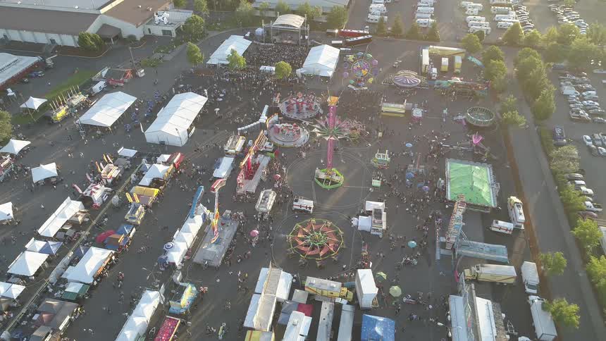 People walk around the grounds and rides of a carnival