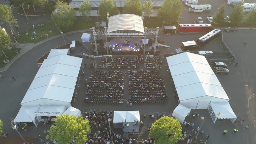 People are attending a concert at an open air theater in daylight