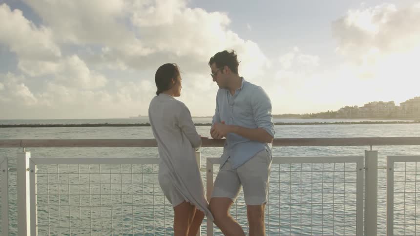 A man and woman talk together by the shore