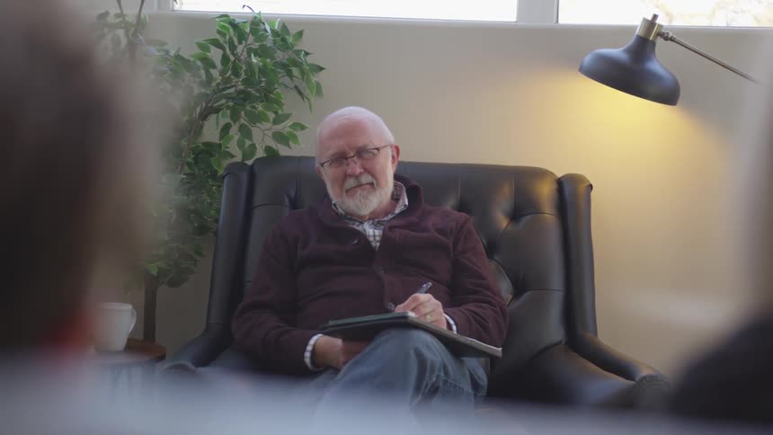 A man smiles in the leather chair