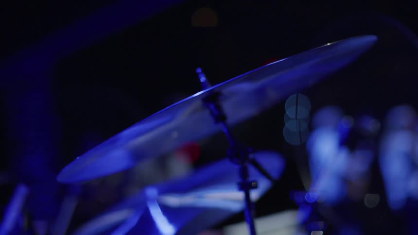 A drummer plays with a band on stage