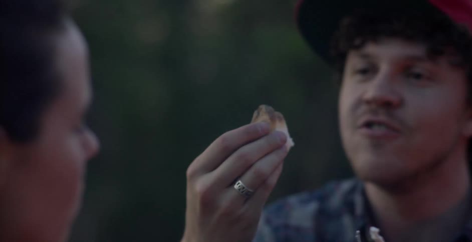 Man and women eat some marshmallows they just toasted together