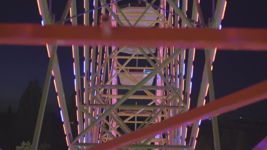 The ferris wheel is brightly lit as it turns