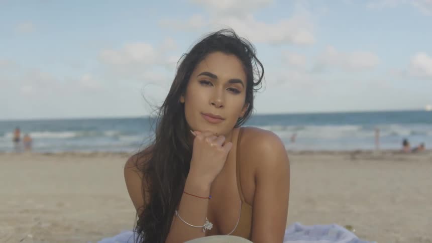 Woman lays on the beach posing