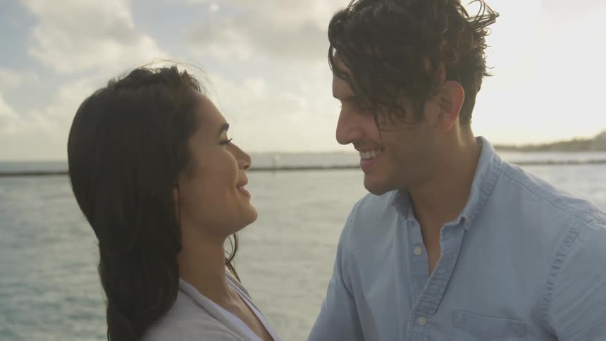 A man and woman stand close by the water