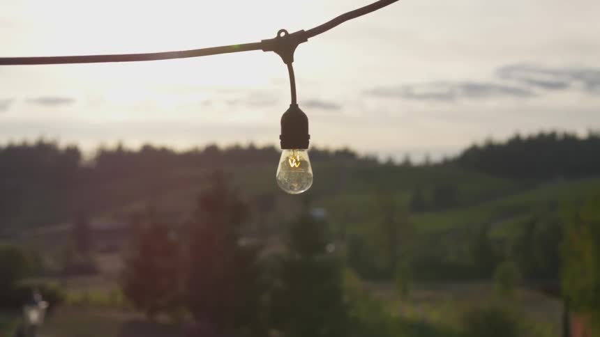 Single light bulb hangs on a wire outside