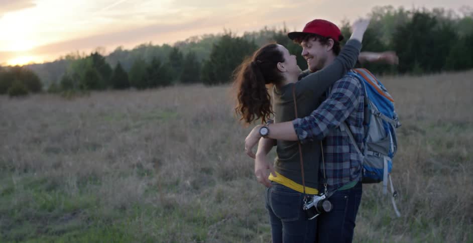 Man and woman kissing and laughing in a field