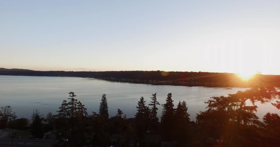 Sun sets over the shore of a river
