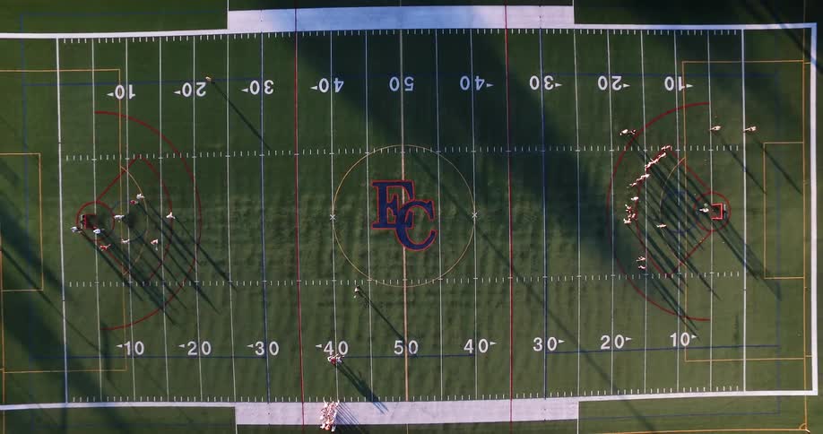 A school logo and players on a football field