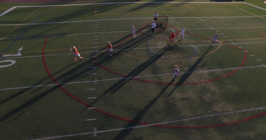 People play lacrosse on a school's athletic field