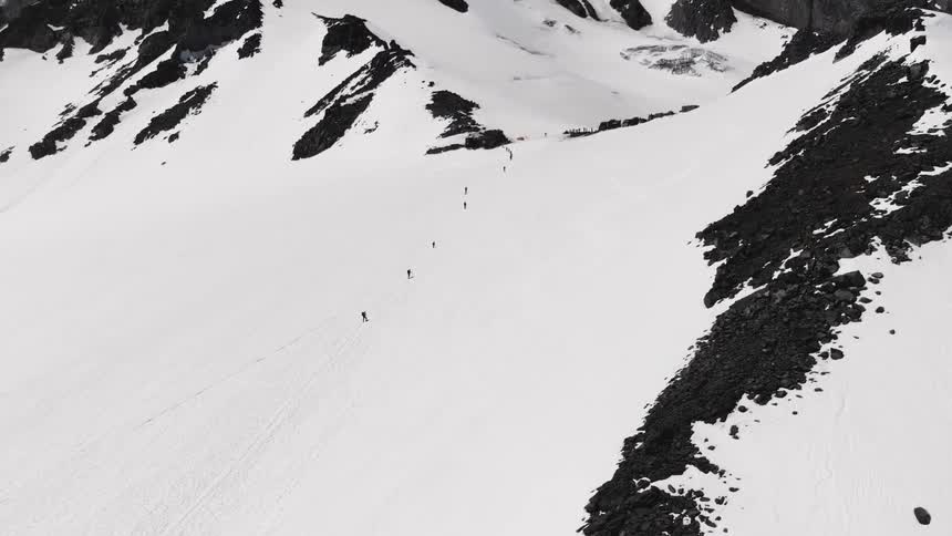 The people hike up the snow covered mountain