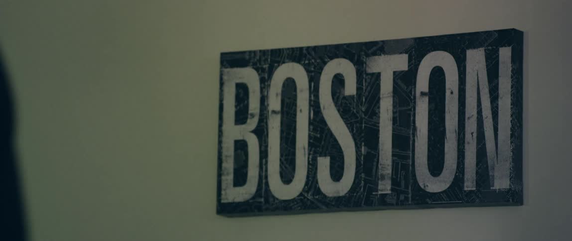 People walk past the sign that says boston