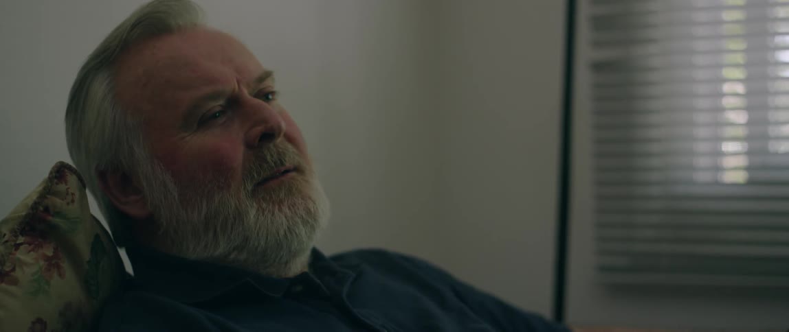 A man leans back listening in the chair