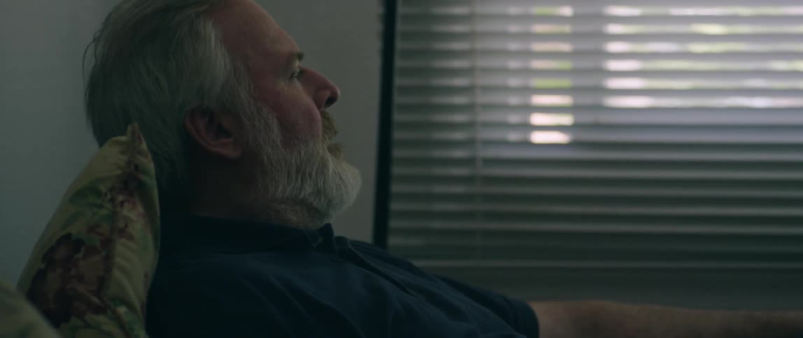 Elderly man sits in a chair in an office